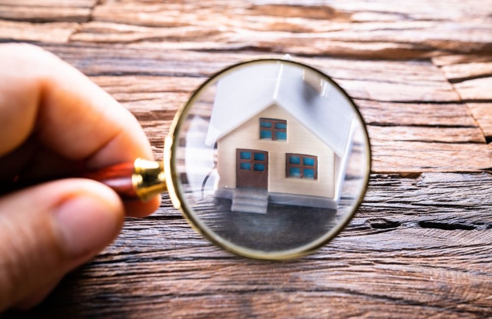 An image of a small house under a magnifying glass.